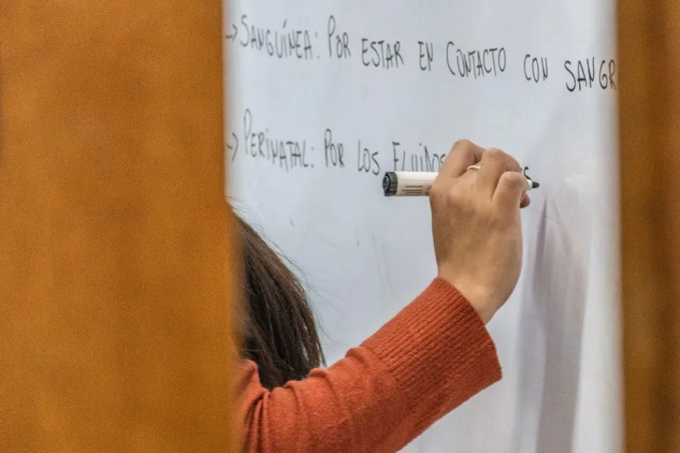 Una estudiante escribe en un pizarrón durante una actividad educativa.